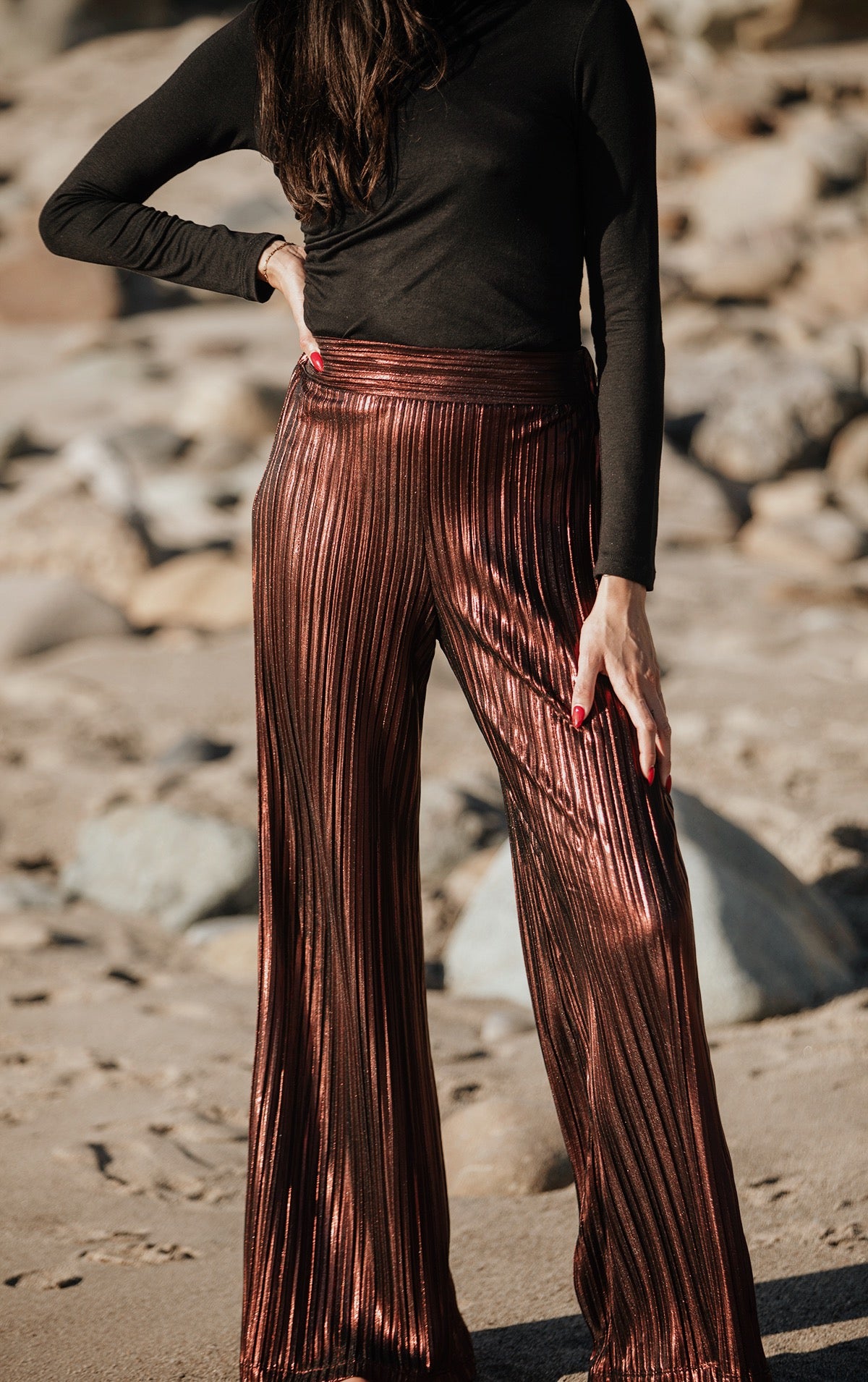 These metallic pleated wide leg pants will make any occasion sparkle. Crafted with an elastic back waistband for comfort, this loose-fit design has a high rise with a clean front waistband and flattering pleats throughout. An exclusive and elegant addition to your wardrobe. Complete the look and pair back to our Wrap Collar Top for a classic Fall look. 