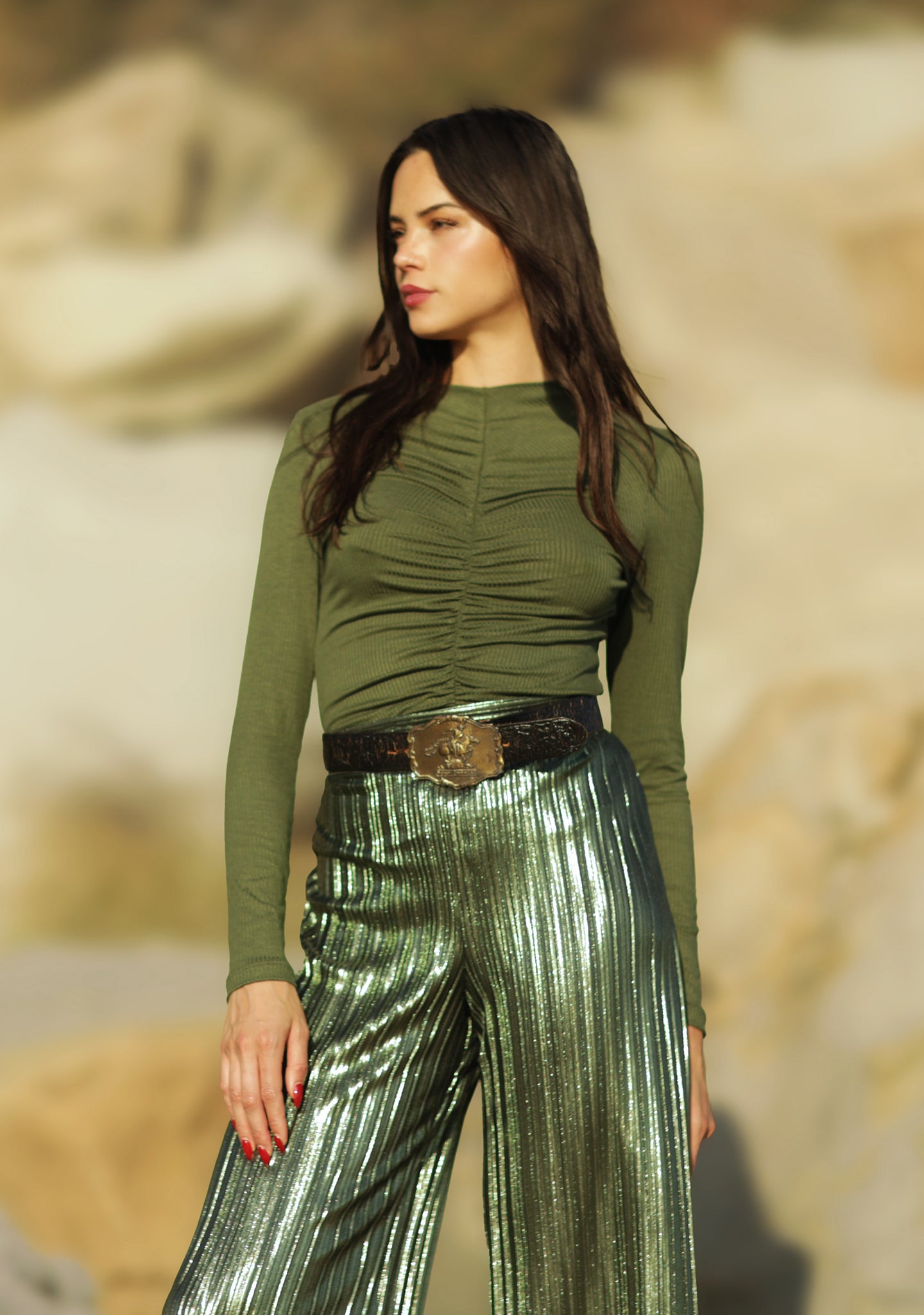 These metallic pleated wide leg pants will make any occasion sparkle. Crafted with an elastic back waistband for comfort, this loose-fit design has a high rise with a clean front waistband and flattering pleats throughout. An exclusive and elegant addition to your wardrobe. Complete the look and pair back to our Rib Ruched Top for a classic Fall look. 